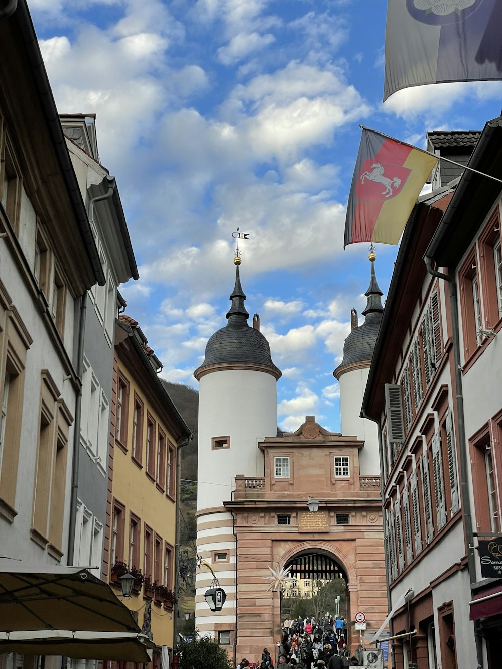 Un groupe de personnes marchant dans une rue à côté de grands immeubles