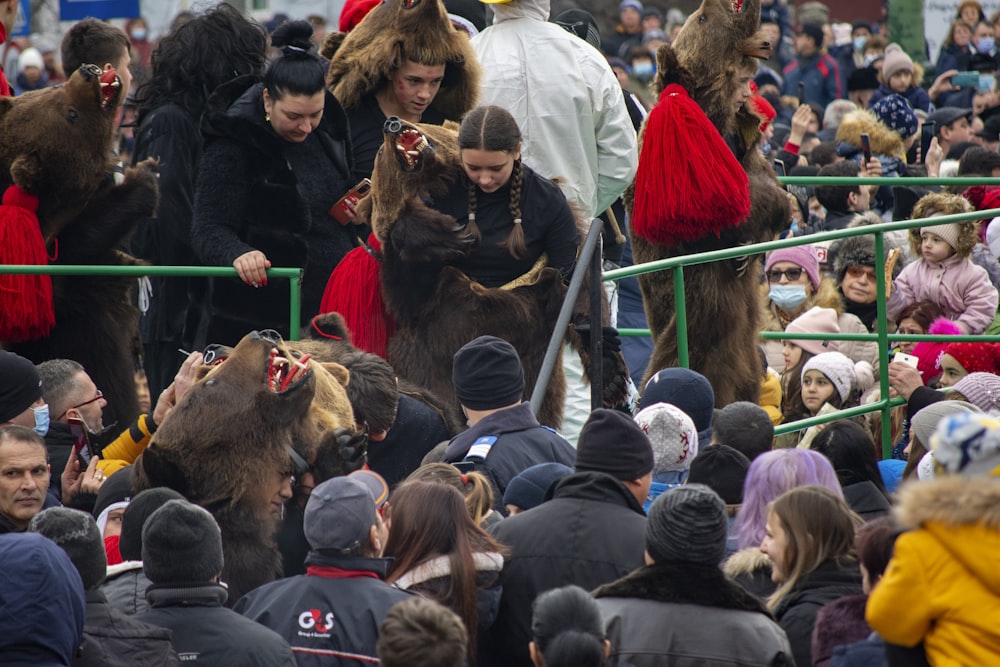 a crowd of people standing around a man in a bear costume