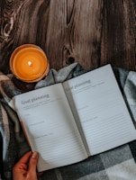 a person holding a book with a candle on top of it