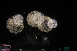 Aerial view of a fireworks display above a large outdoor festival.