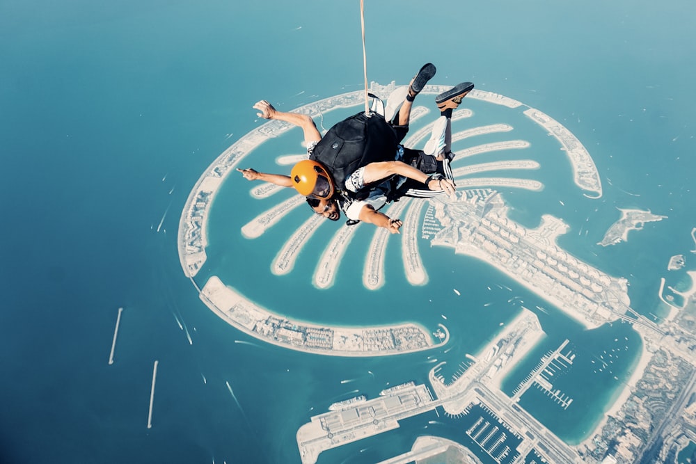 a man flying through the air while riding a parachute