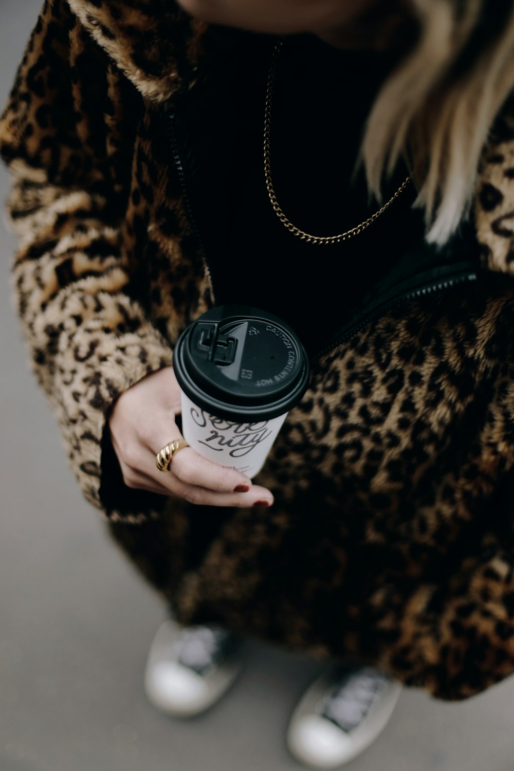 a woman is holding a cup of coffee