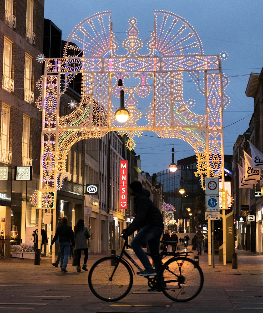 a man riding a bike down a street next to tall buildings