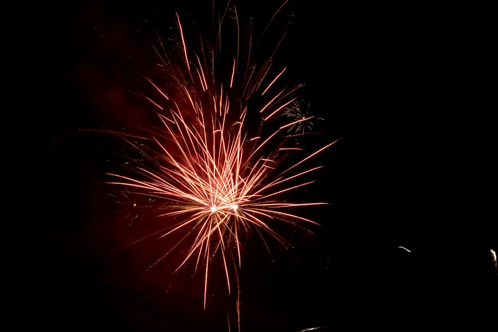 a red fireworks is lit up in the night sky