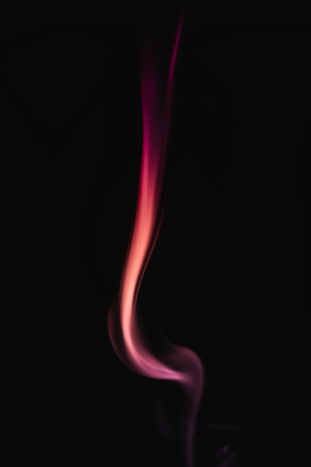 a red and pink smoke on a black background