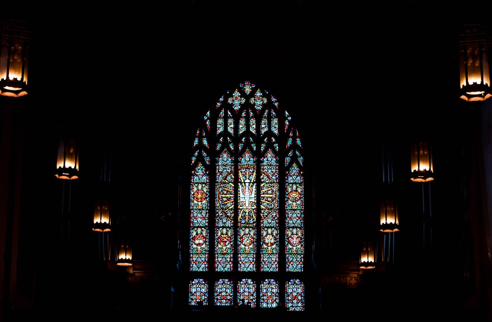 a large stained glass window in a dark room