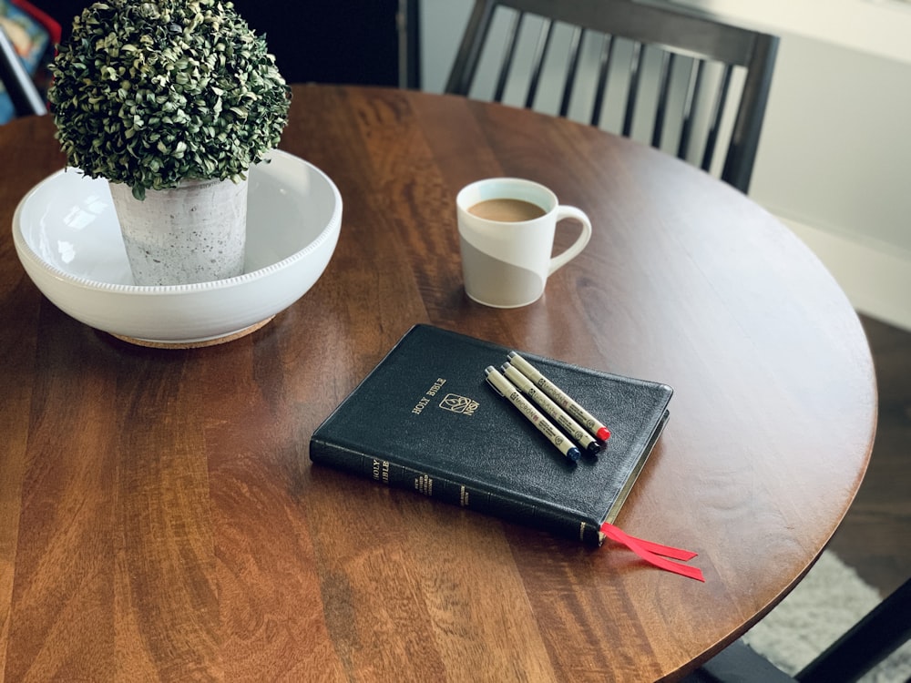 a wooden table topped with a book and a cup of coffee