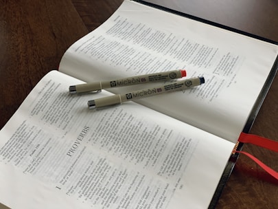An open Bible with a pen resting on top, symbolizing guidance and wisdom.