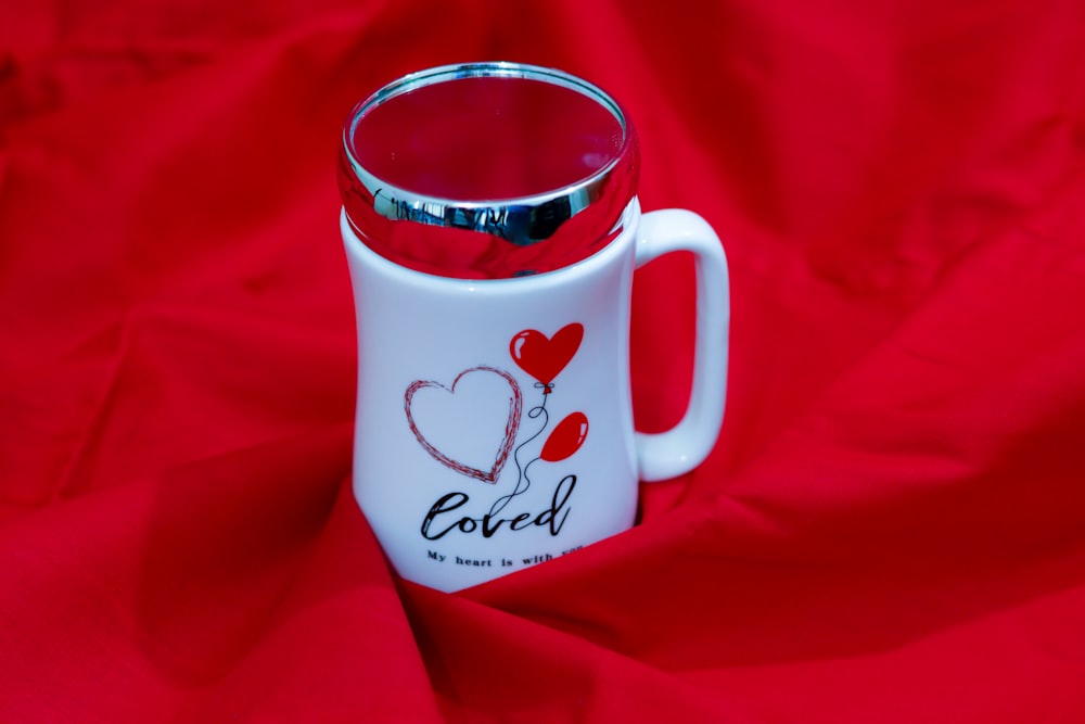 a red and white coffee mug with a heart on it