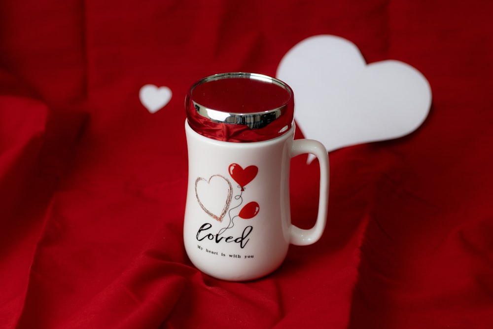 a red and white coffee mug with a heart on it