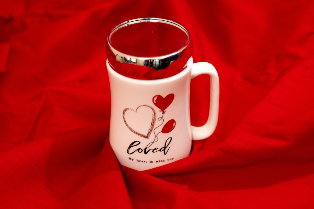 a red and white coffee mug with a heart on it