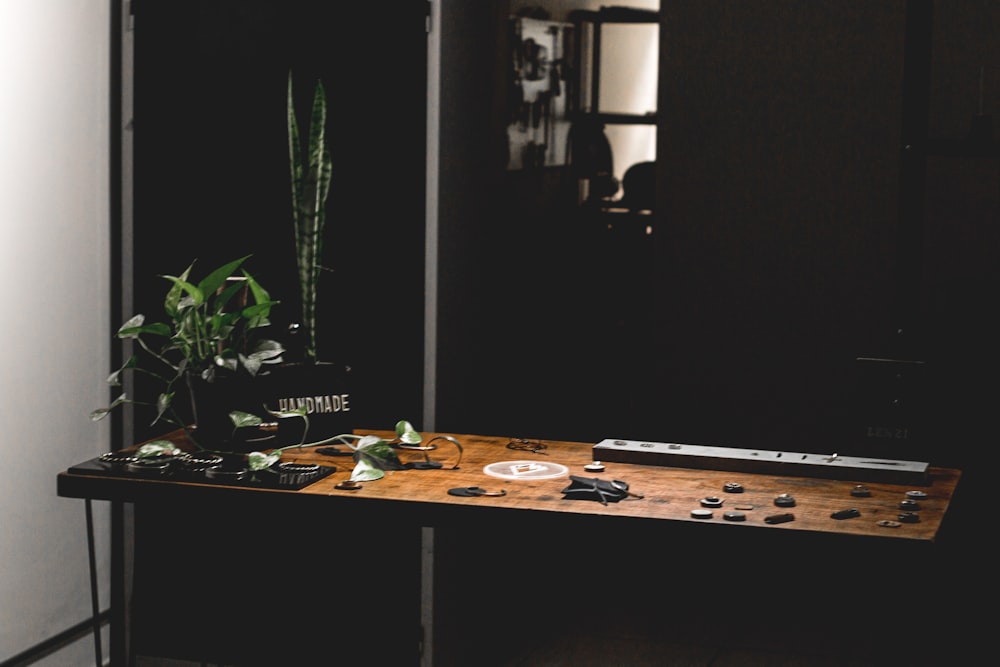 a wooden table topped with a plant next to a mirror