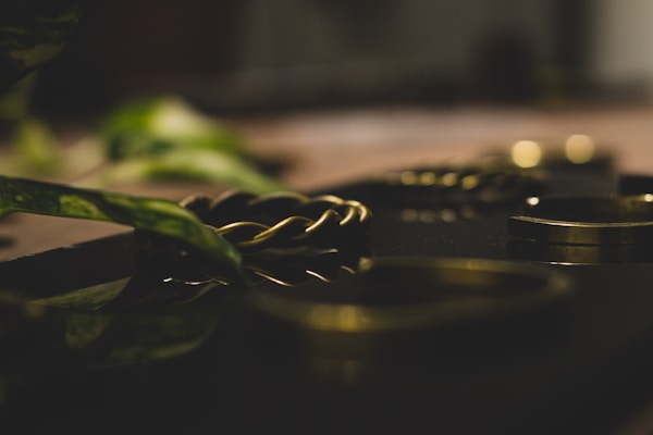 A close-up of elegant metal bracelets displayed on a soft fabric background.
