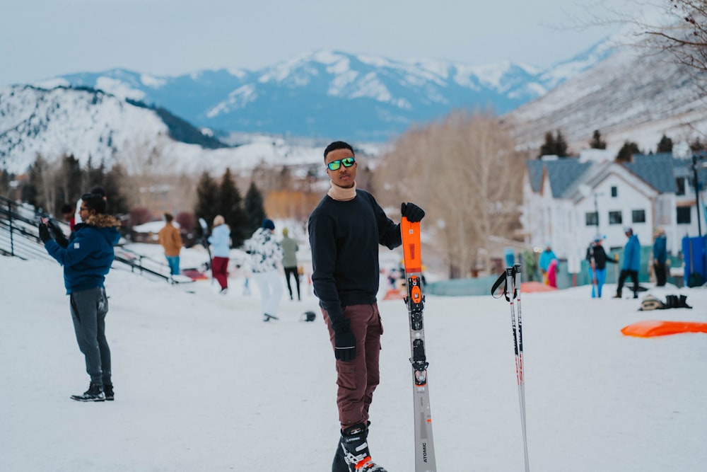 a man standing in the snow with skis and poles