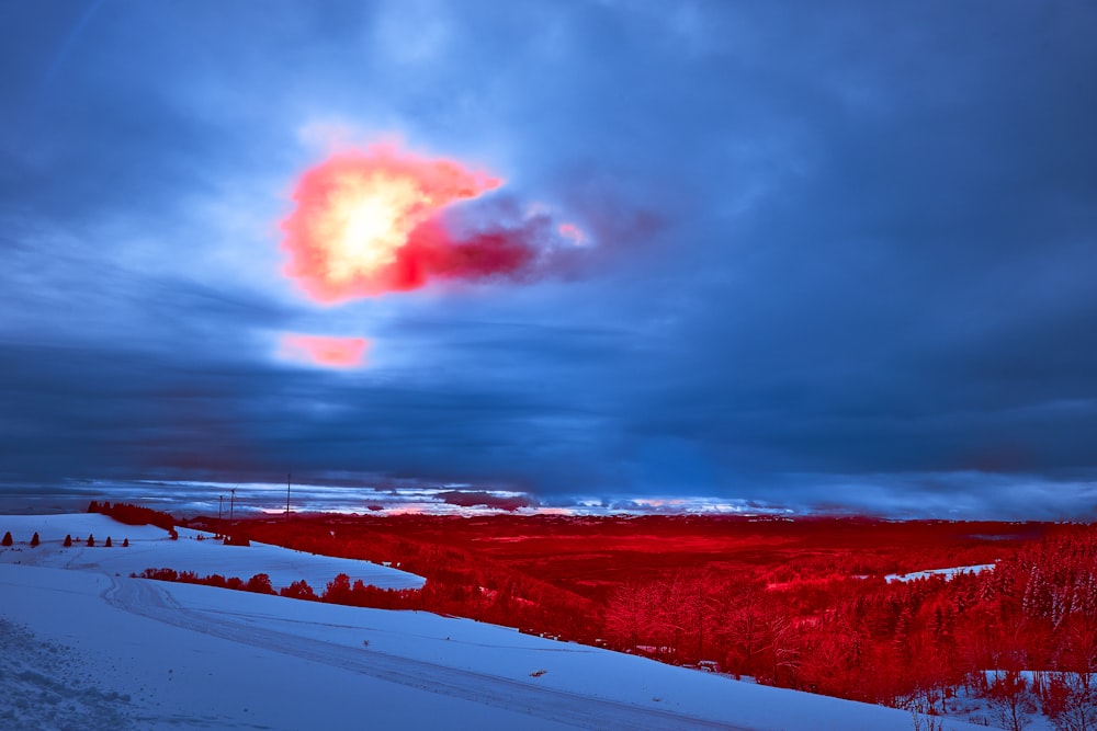 a red object is in the sky above a snowy field