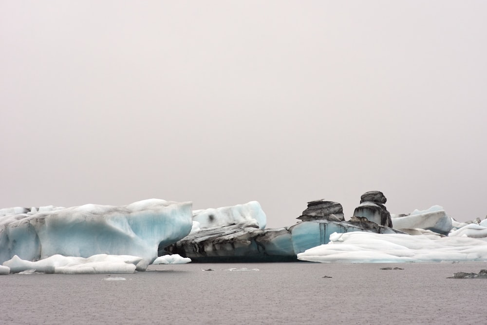 a group of icebergs floating on top of a body of water