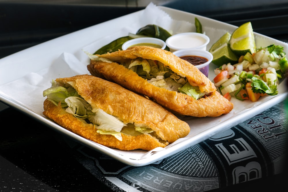 une assiette blanche garnie d’un sandwich et d’une salade