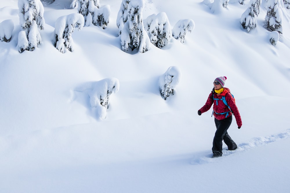 a person in a red jacket is walking through the snow