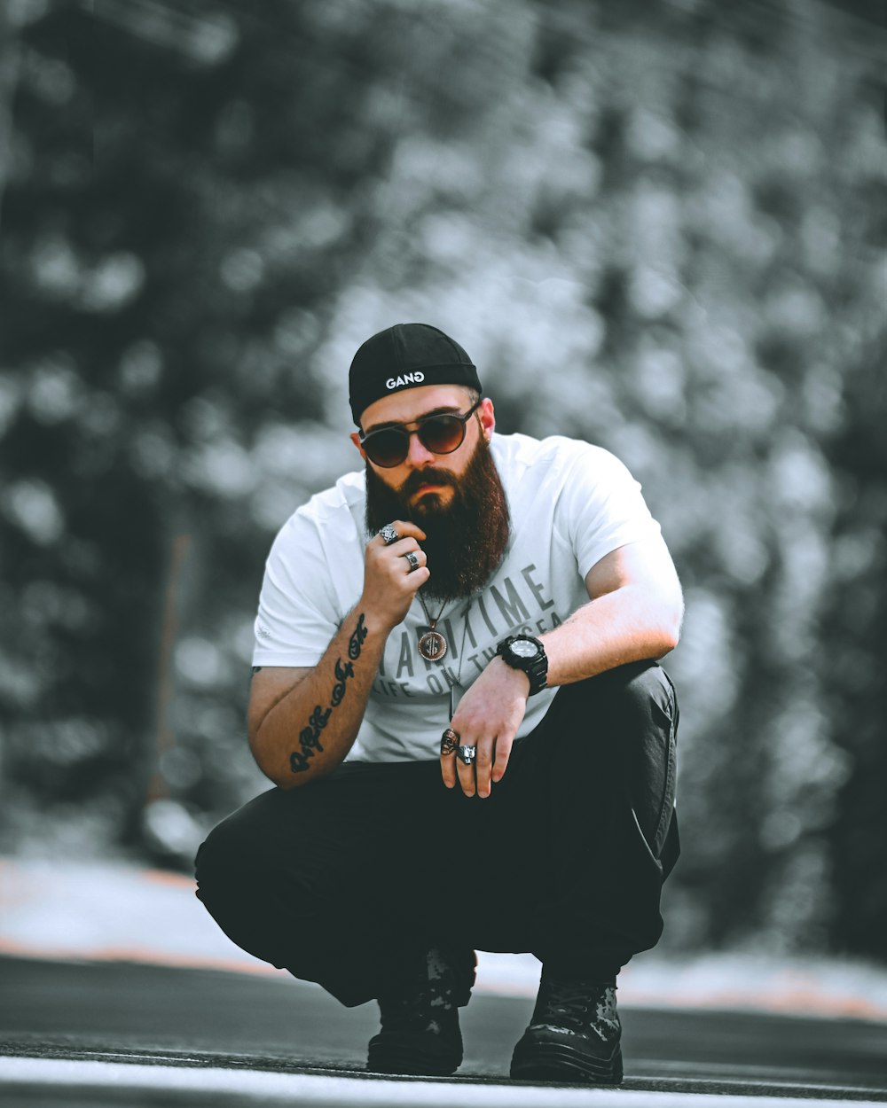 a man with a beard squatting on a skateboard