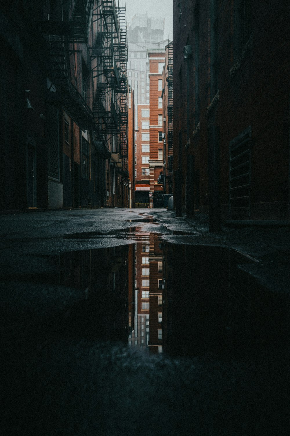 a city street with a puddle of water in the middle of it