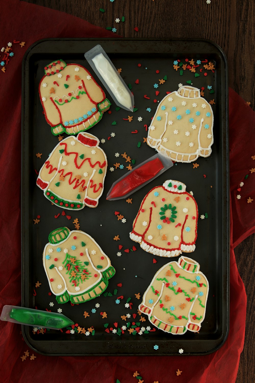 a tray of decorated christmas sweaters and mittens