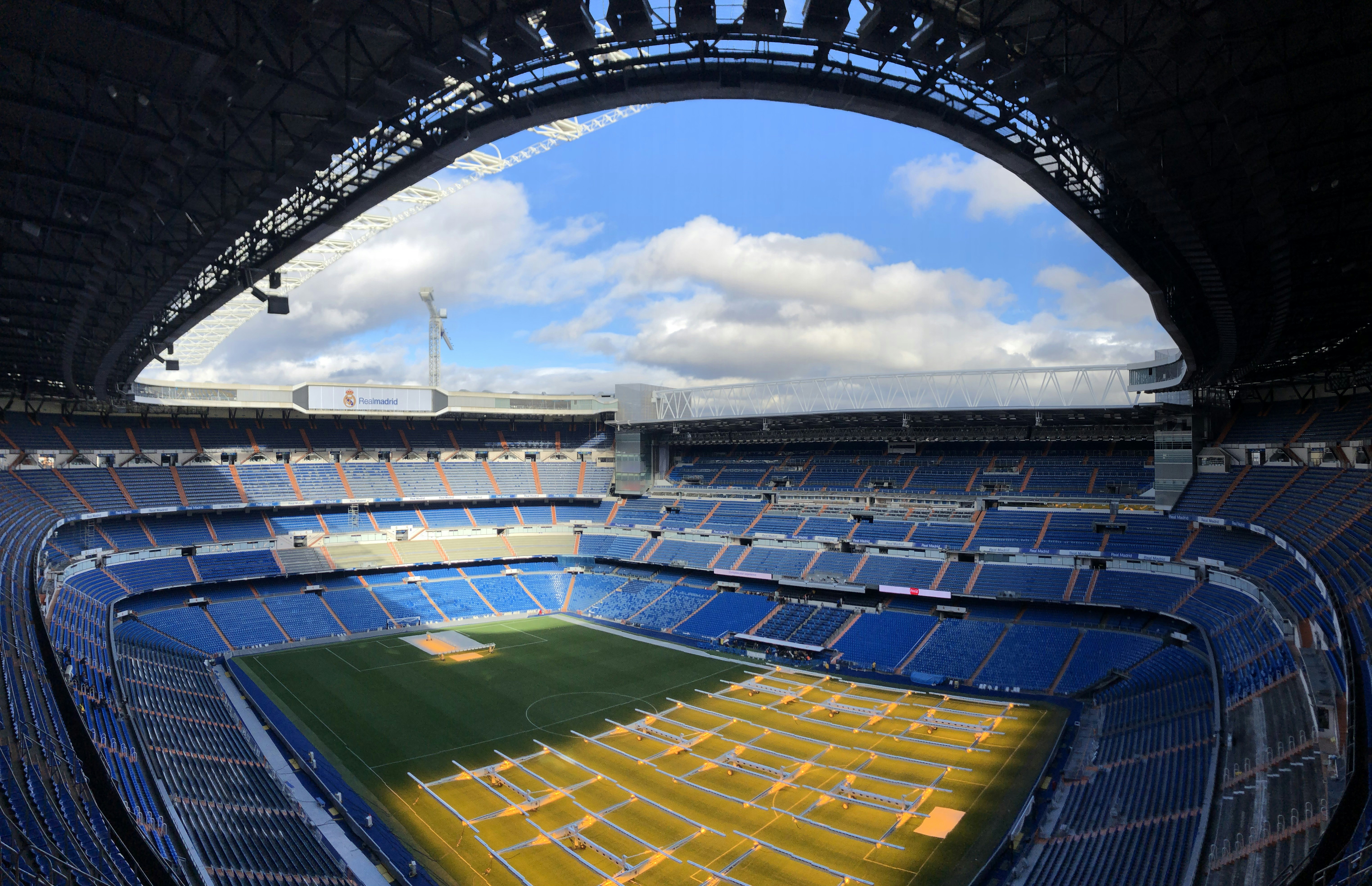 an empty stadium with a blue sky and clouds