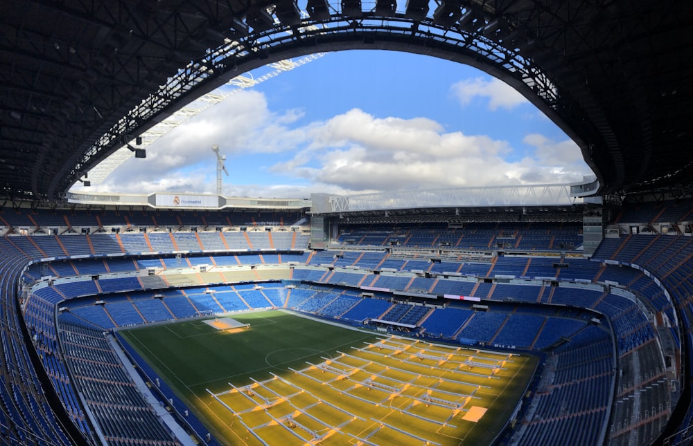 an empty stadium with a blue sky and clouds