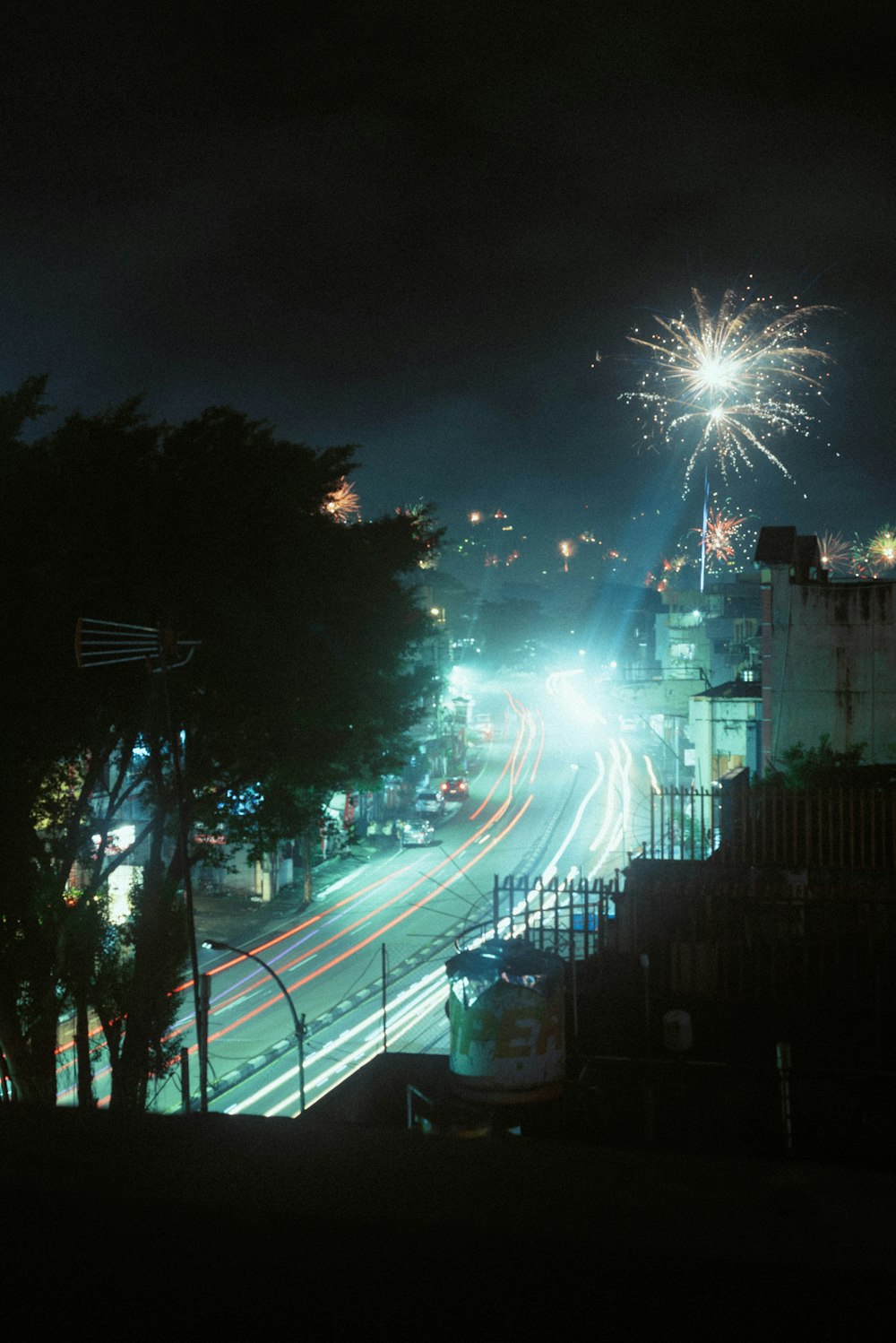a city street at night with fireworks in the sky
