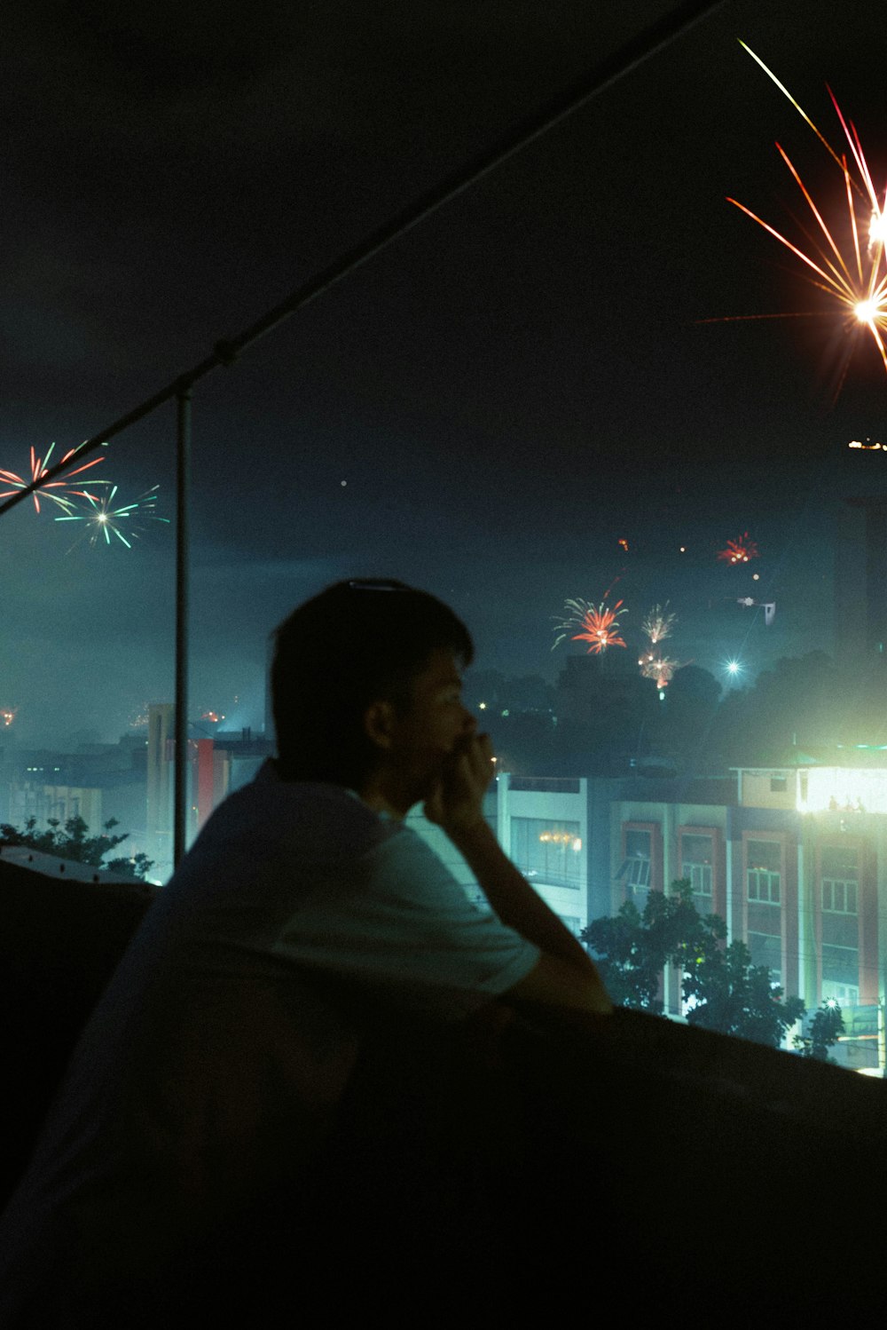 a man sitting on a ledge with a cell phone to his ear