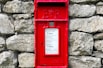 a red post box on a stone wall