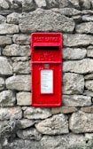 a red post box on a stone wall
