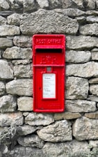 a red post box on a stone wall