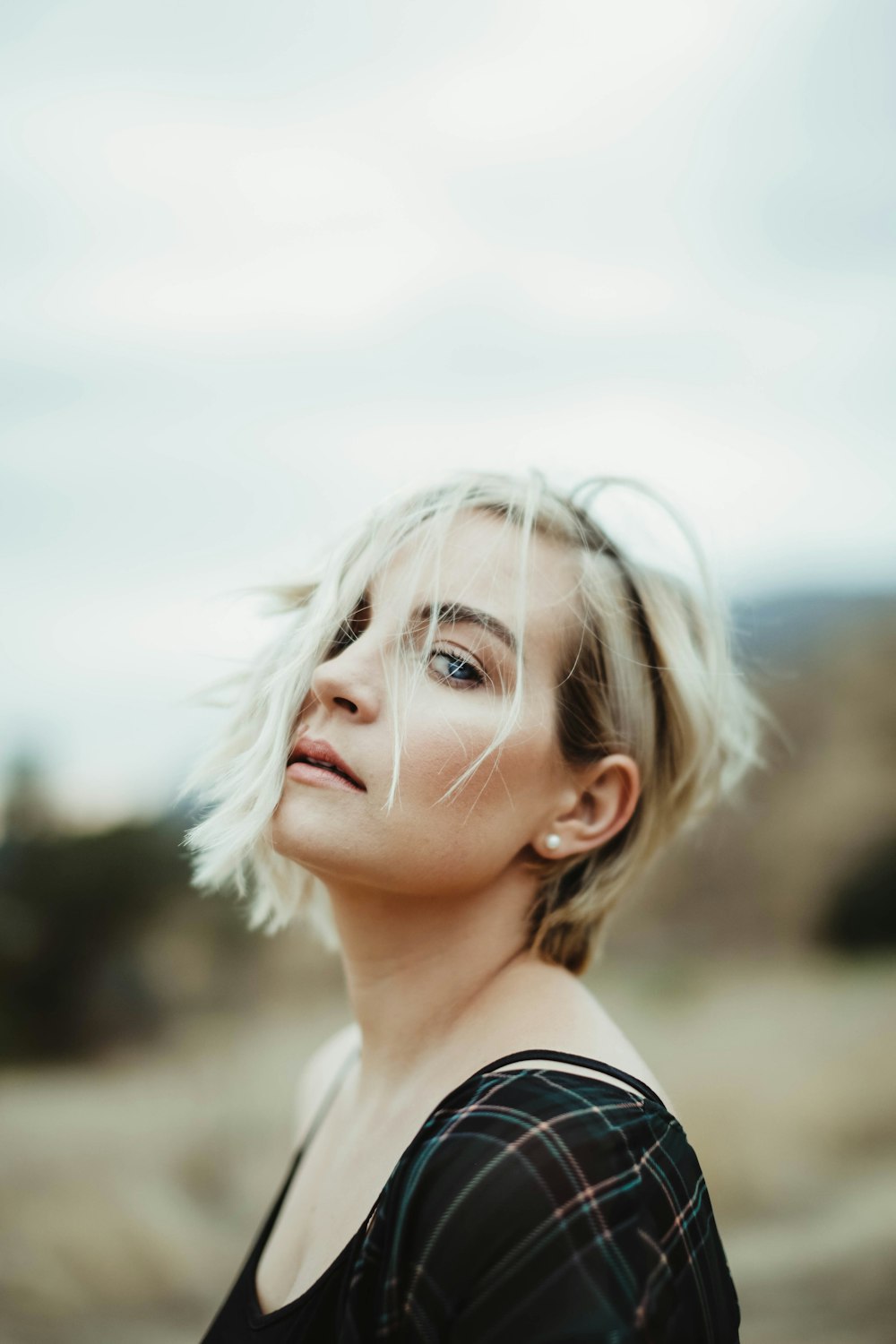 a woman with blonde hair standing in a field