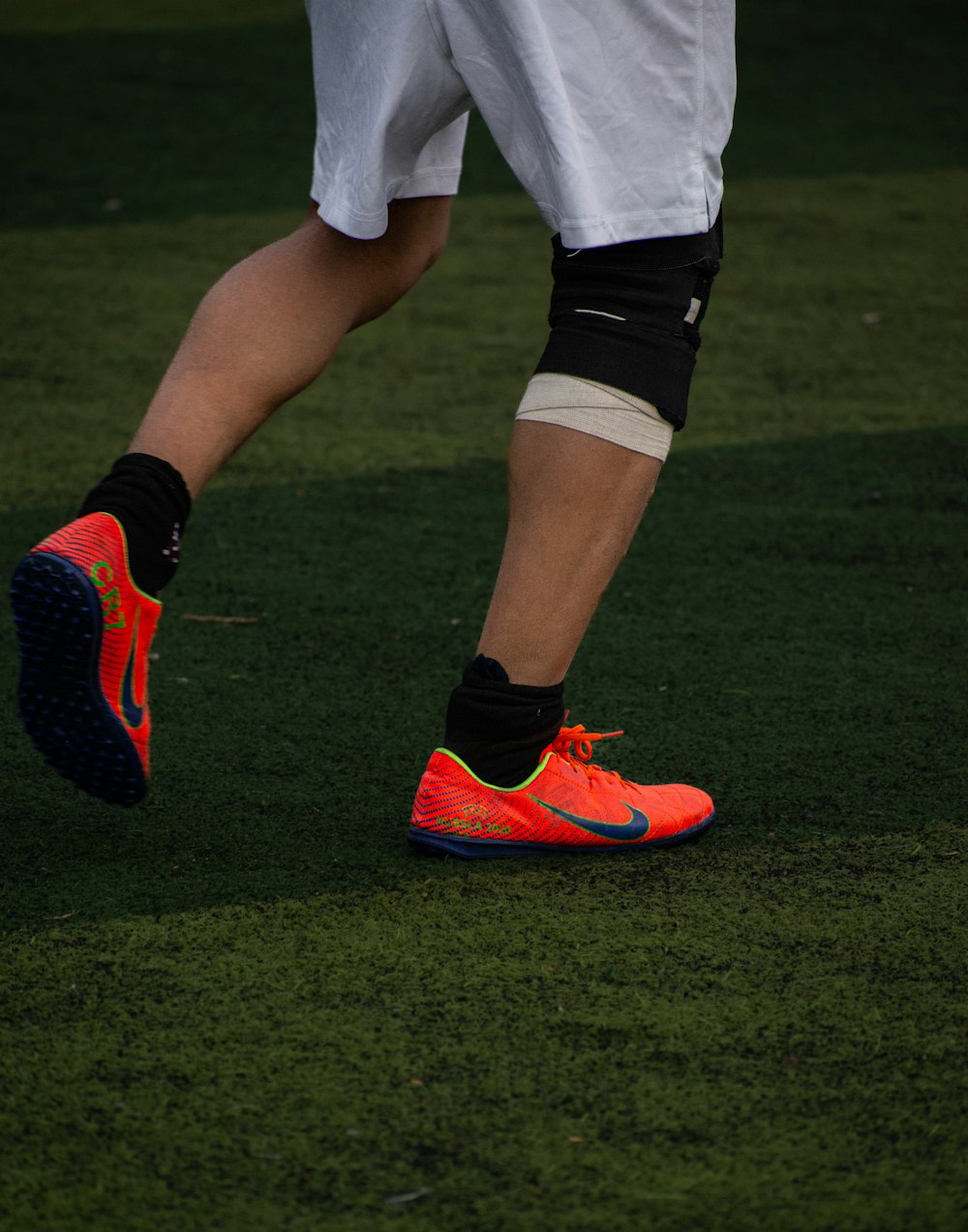 a close up of a soccer player's shoes on the field