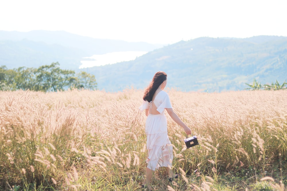 a woman standing in a field of tall grass