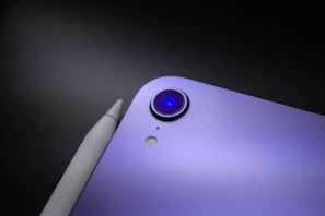 Close-up of a sleek purple kitchen gadget with a modern design on a white countertop.