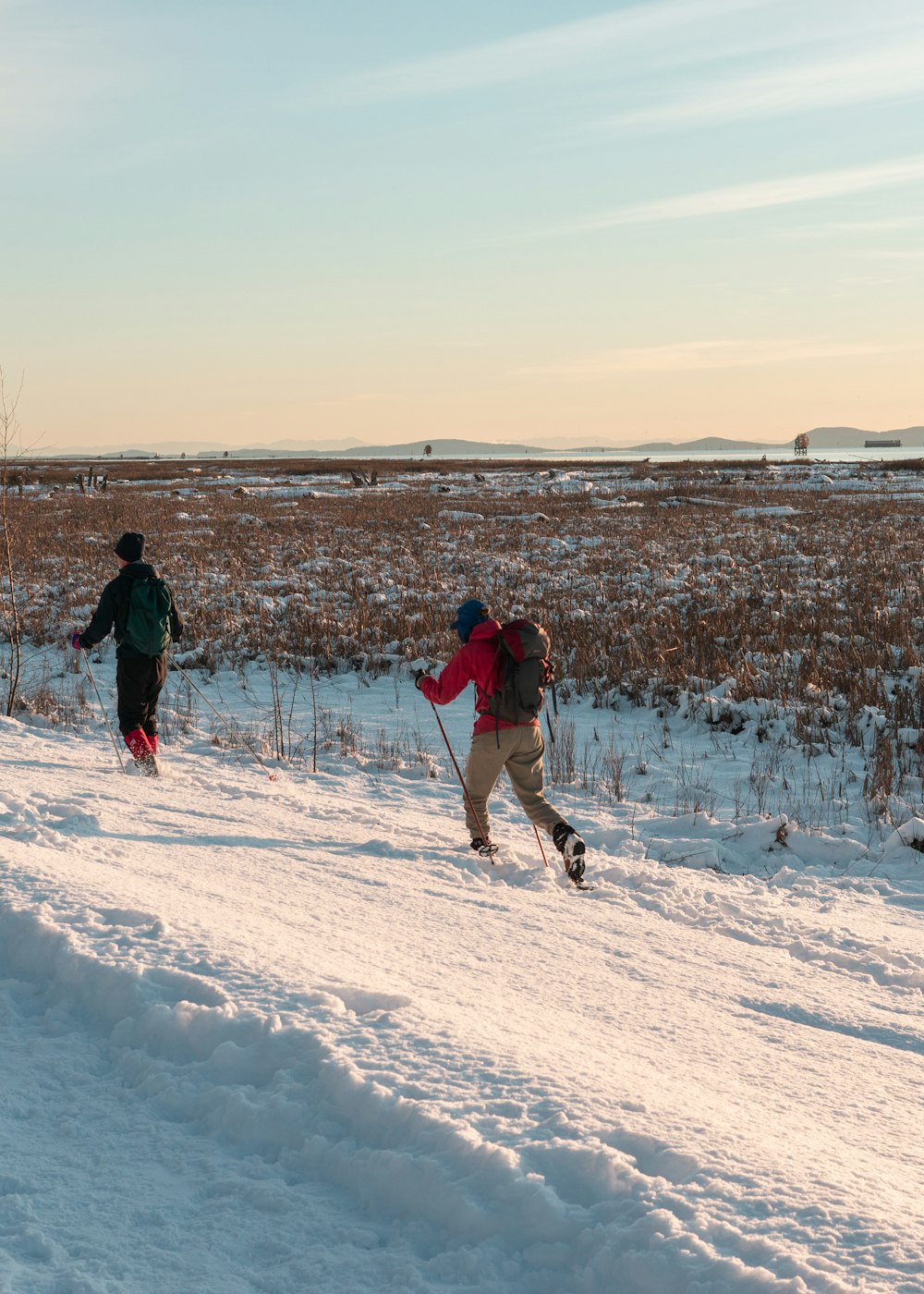 a couple of people riding skis down a snow covered slope