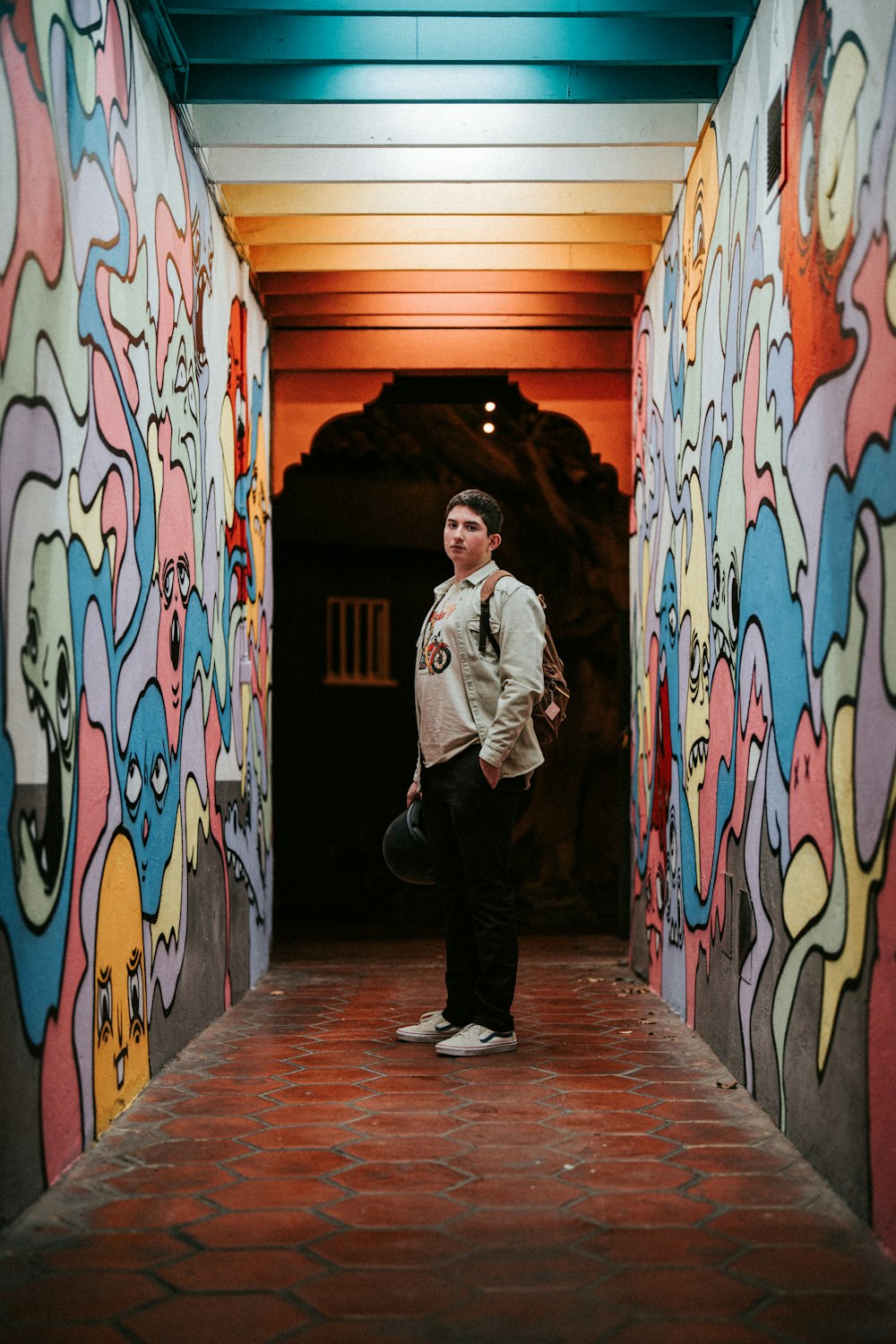 a man standing in a tunnel with a skateboard