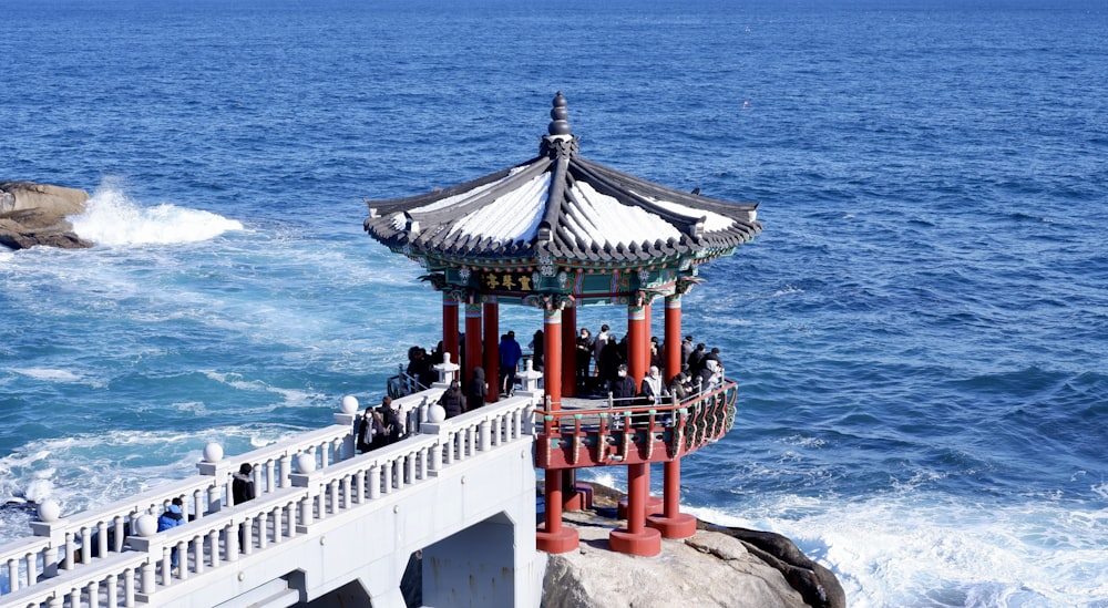 a gazebo sitting on top of a cliff next to the ocean