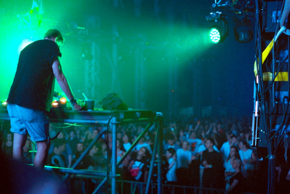 a man standing on top of a table in front of a crowd