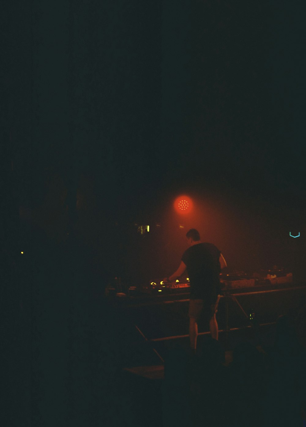 a man standing in front of a red light at night