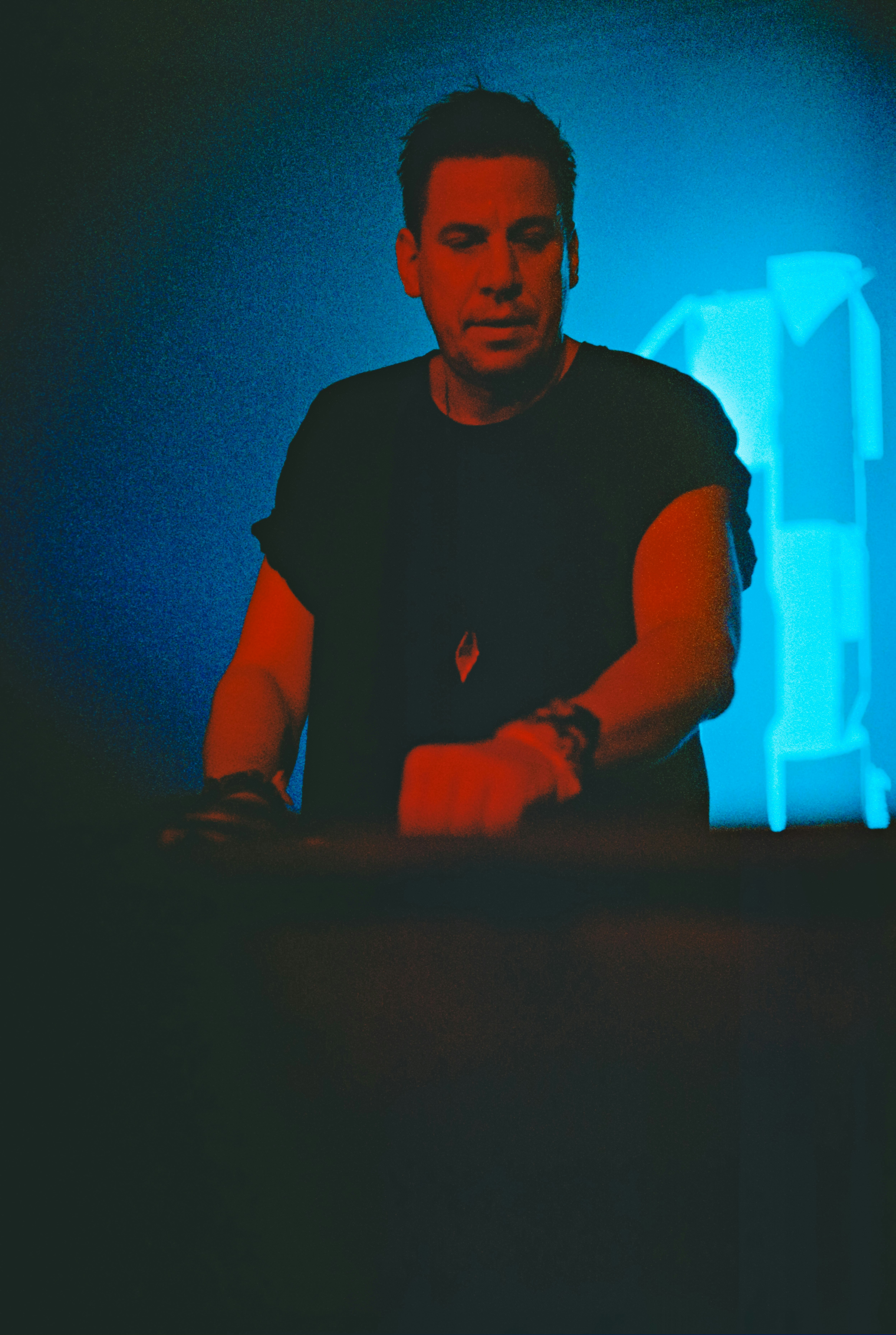 a man sitting at a table in front of a blue light