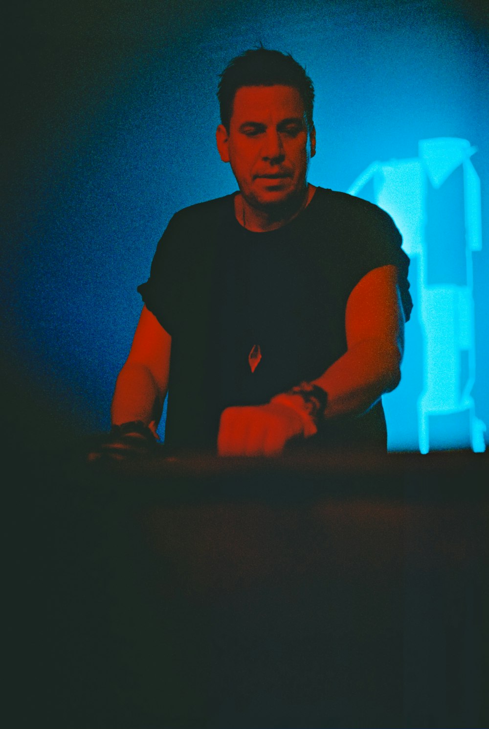 a man sitting at a table in front of a blue light