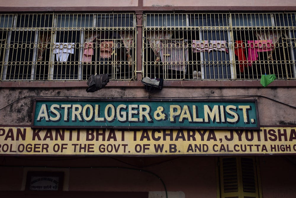 a sign on the side of a building that says astrologger and palmist