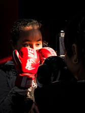 a young girl wearing red boxing gloves