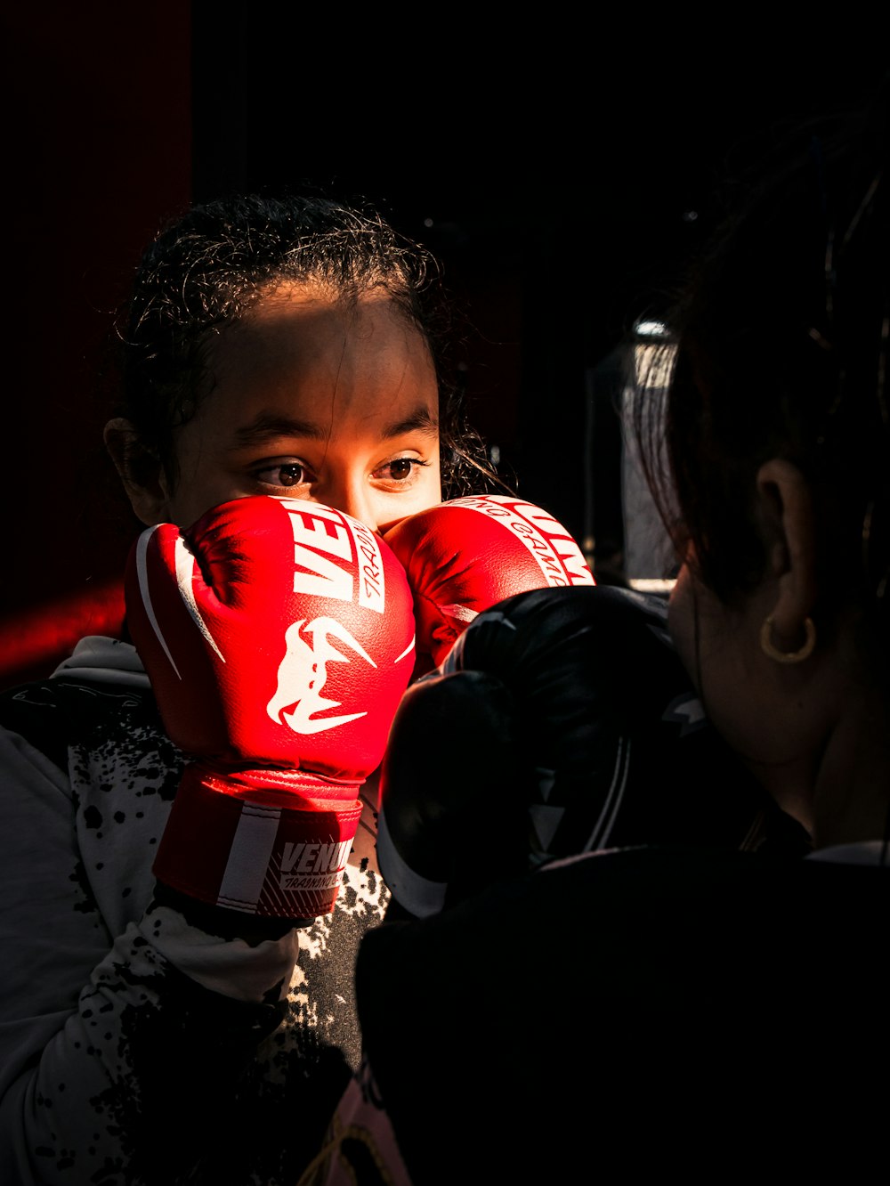 a young girl wearing red boxing gloves