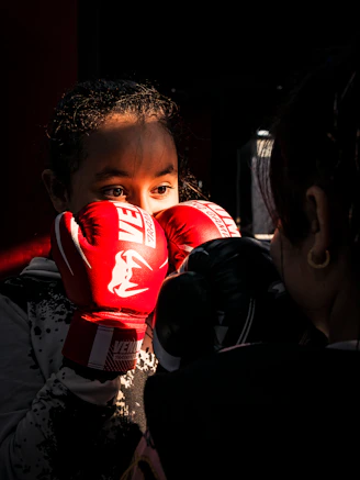 a young girl wearing red boxing gloves