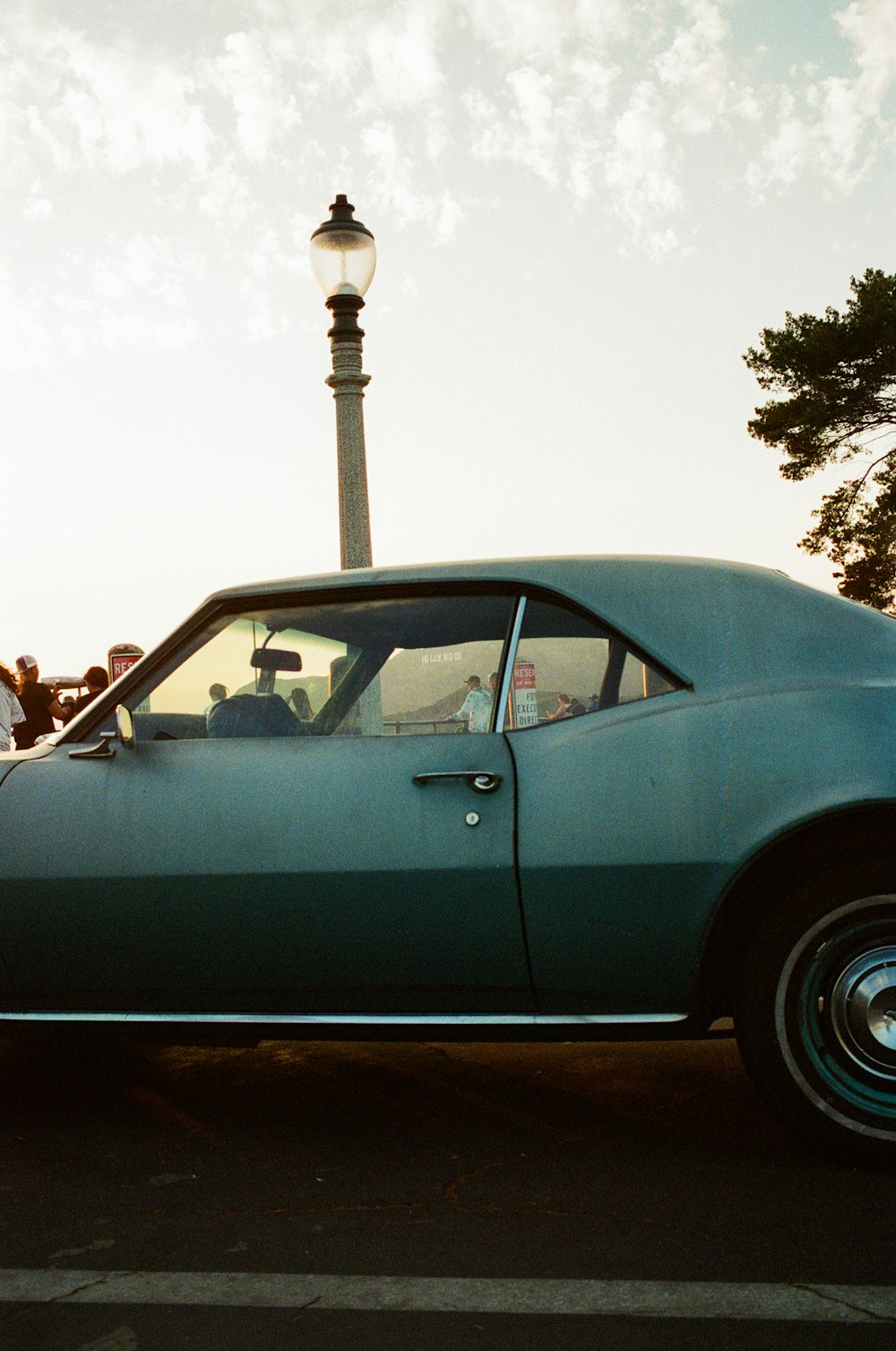 a blue car parked in front of a street light