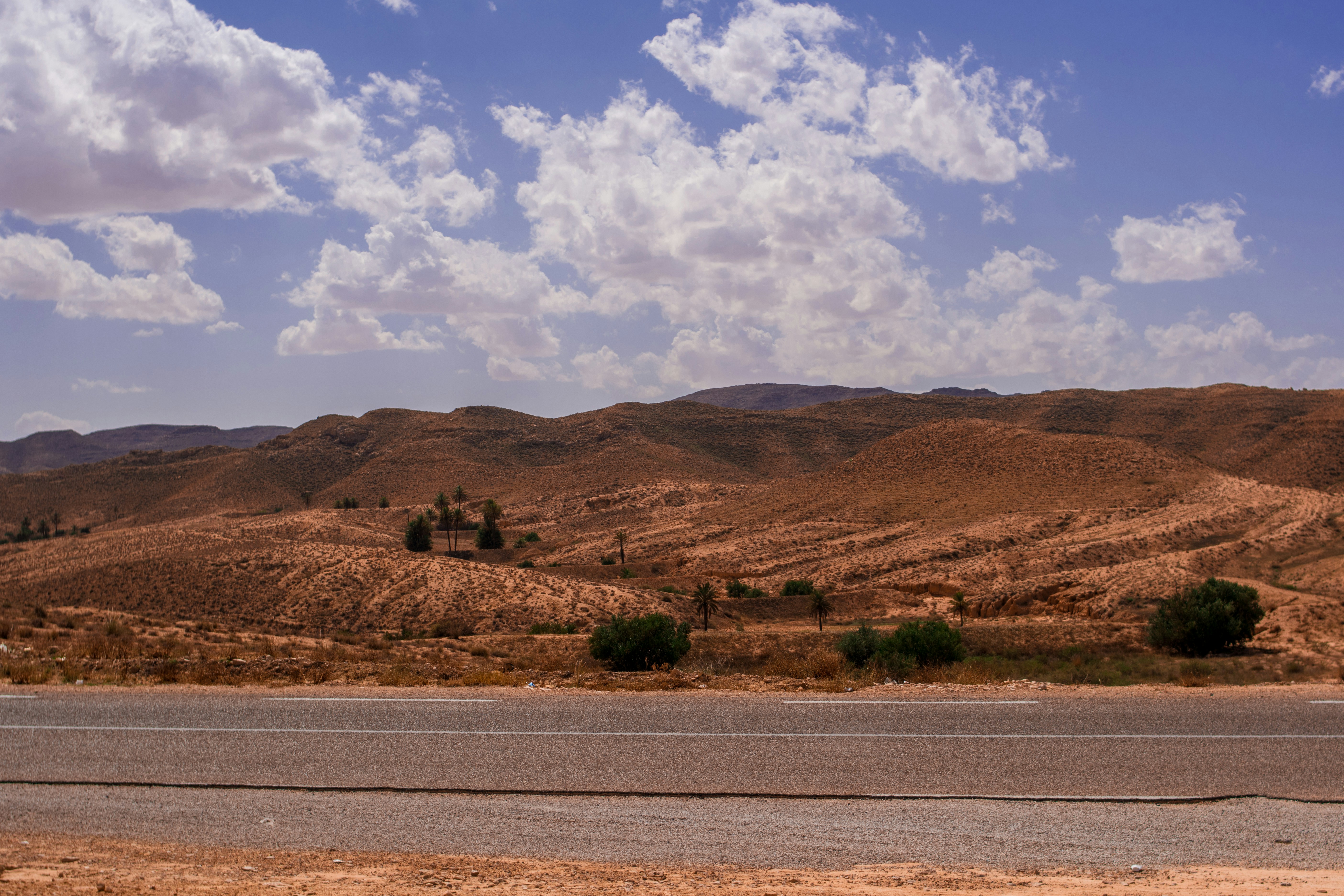 a road in the middle of a desert with mountains in the background