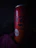 Close-up of a man holding a chilled can of Divorox Zero with condensation, set against a neon-lit urban backdrop.
